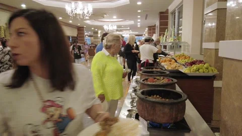 A crowd of resort guests in the lobby of a buffet restaurant choose their foo Stock Footage 198238452