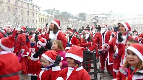 Crowd of Santa Clauses kids dancingcrazy  together heavy snow for new year Stock Footage 70647293