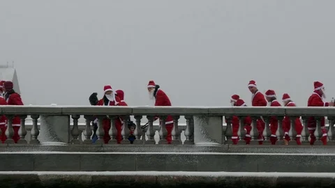 Crowd of Santa Clauses running taking mobile picture in street, snow new year Stock Footage 70645829