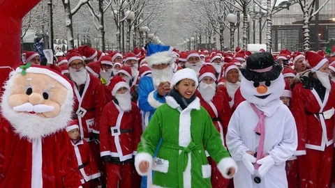 Crowd of Santa Clauses standing together under heavy snow for new year charity Stock Footage 70644517