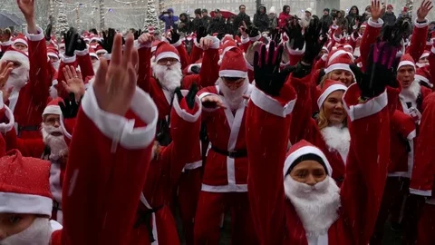Crowd of Santa Clauses warming up dancing, moving shaking heavy snow new year Stock Footage 70645435