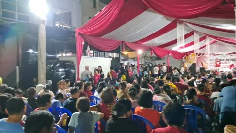 Crowd Sitting Under Red and White Event Tent Outdoors Stock-Footage 343587335