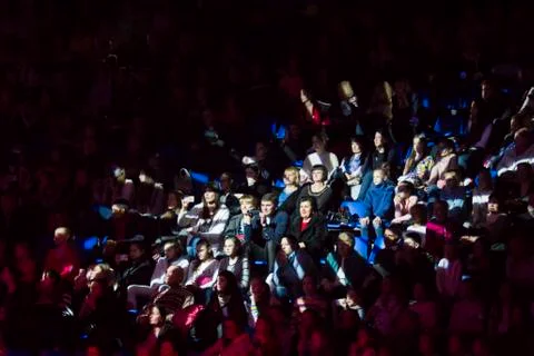 Crowd of spectators lit by a spotlight Stock Photos