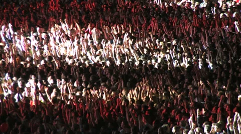 Crowd of spectators on the stadium waving hands and applauding in the spotlight Stock Footage 39709689