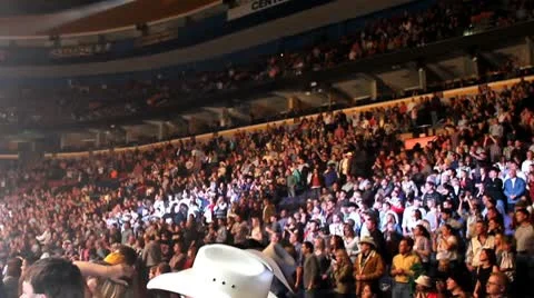 Crowd in a stadium with spot lights dancing around Stock Footage