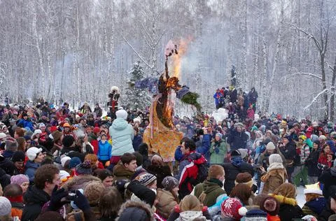 A crowd standing around the burning Maslenitsa doll Stock Photos