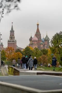 Crowd strolls through a park with St. Basils Cathedral and the Kremlin in t.. Stock Photos