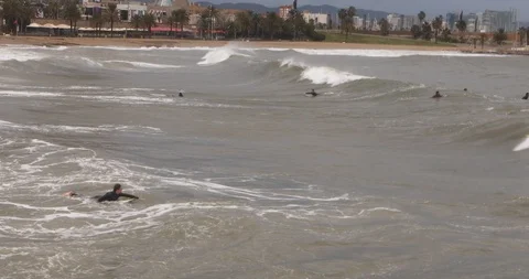 Crowd of Surfers trying to catch big waves in Barcelona beach Stock Footage 125868749