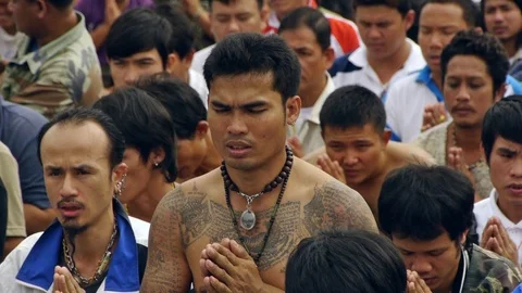 A crowd of tattooed devotees at Wat Bang Phra praying. Stock Footage 121087552