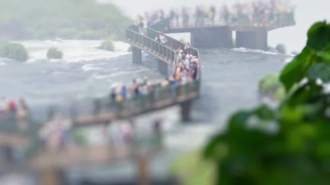 Crowd of tourists watch powerful waterfall with strong water flow Stock Footage 341569209