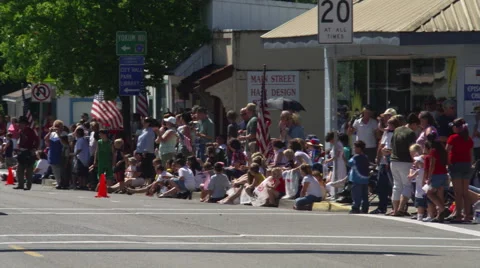 Crowd waiting for parade on small-town sidewalk Video stock 59455532