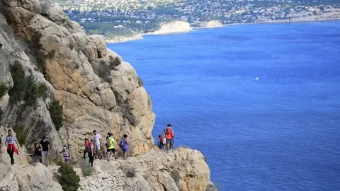 Crowd walk by the narrow path ascending to the Penon of ifach in Calpe, Spain Stock-Footage 141508615