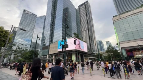 Crowd walking by digital billboard and skyscrapers in BGC Taguig 4K Stock-Footage 337950714