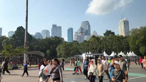 Crowd walking in Jakarta park with modern city skyline background Stock Footage 340939157
