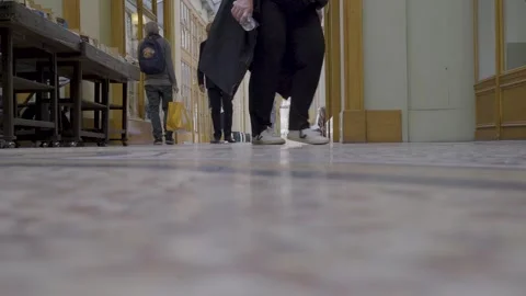 Crowd walking through a busy Parisian arcade, focusing on the floor and Stock Footage 305755867