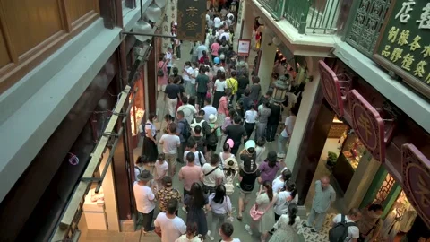 Crowd walking through small street high angle from behind Stock-Footage 162567312
