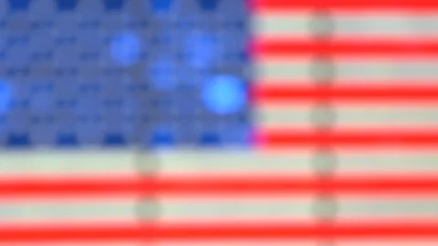 A crowd walks in front a lighting and neon American flag blur Time square NYC Vídeos de archivo 128467840