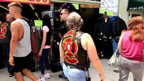 A crowd walks the Weirs Beach sidewalk at Laconia Motorcycle Week 2018 Stock Footage 94011380