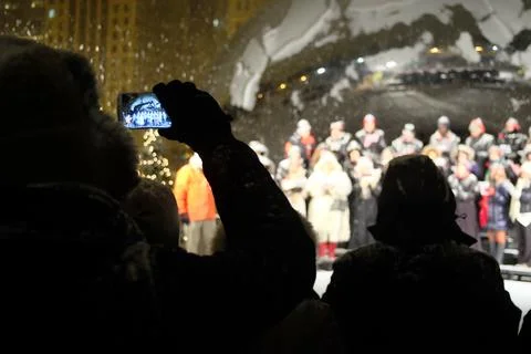 Crowd watching a choir performance during snowy winter night Stock Photos