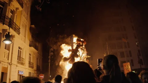 Crowd watching falla sculpture burning on Valencia street during Las Fallas Stock Footage 336722444