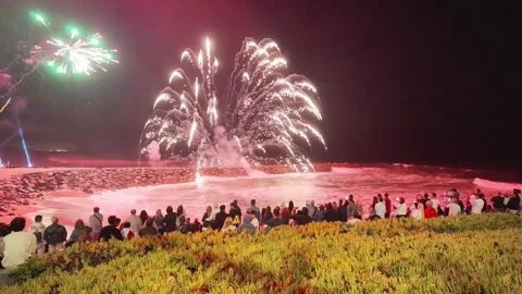 Crowd watching a fireworks display over the ocean at Praia de Cortegaça Stock Footage 344907735