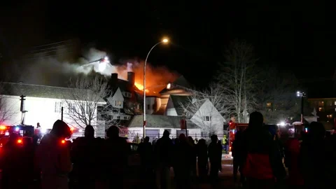 Crowd watching old building burning into flames Stock Footage 139657213