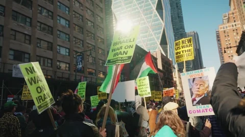 Crowd waves Palestinian flags and Stop US Israeli War On Iran signs Stock Footage 341658010