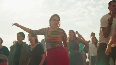 A crowd of young people, fans dancing in front of the stage, enjoying music at Stock Footage 167364643