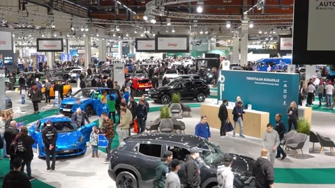 A crowded auto show with people explorin... | Stock Video | Pond5