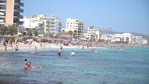 Crowded beach by resorts Stock Footage 128349297