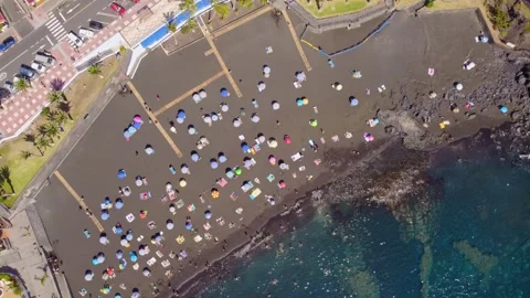 Crowded black volcanic La Arena beach during summer in parallax shot. Stock Footage 244826366