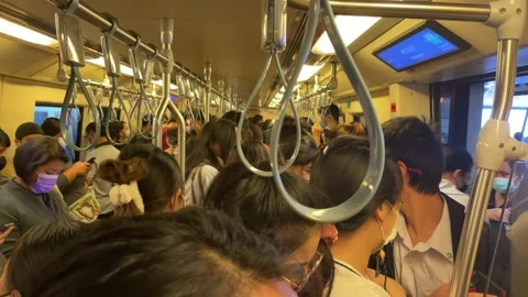 Crowded commuters riding on BTS sky train rush hour. Urban commute, Bangkok Stock Footage 230512070