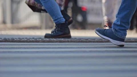 A crowded crosswalk viewed from ground level. Only shoes and legs are visib.. Stock Footage 303346656