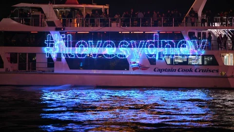 Crowded cruise boat pulling away on water, lit up with neon lights Stock Footage 128402137