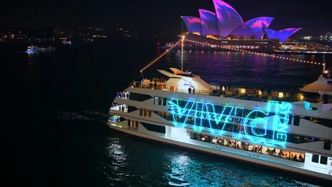 Crowded cruise boat pulling into Circular Quay, lit up with neon lights Stock Footage 128401171