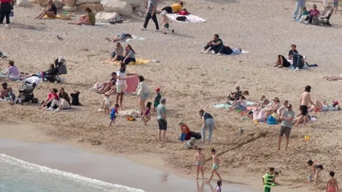 Crowded Mediterranean Beach with Tourists Sunbathing and Swimming Stock Footage 340134213