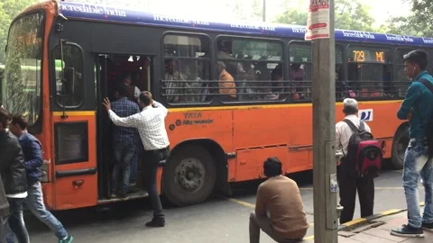Crowded passengers getting on and off the bus at bus stop, Delhi Видео 197004505