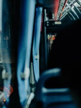 Crowded public bus interior with hanging handles and night city lights Photos