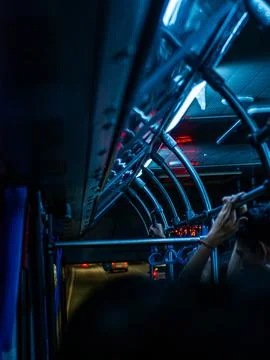Crowded public bus interior with hanging handles and night city lights Photos