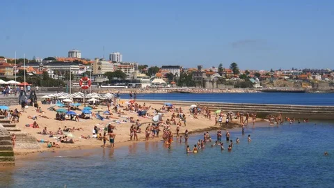Crowded sandy Moitas Beach in Cascais near Lisbon, Portugal during the summer Stock Footage 112885705