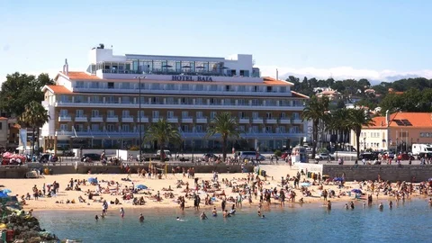 Crowded sandy Praia do Ribeiro in Cascais, Portugal on a sunny summer day Stock Footage 112790064