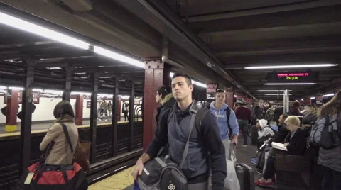 Crowded subway platform passengers waiting for train carrying bags luggage NYC Stock Footage