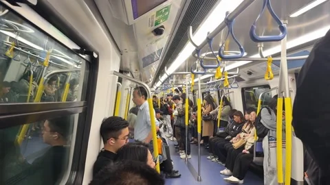 Crowded subway train carriage interior with commuters standing and sitting 動画素材 347131561