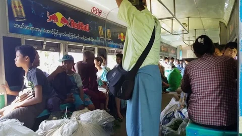 Crowded train wagon, local passengers, monk, produce sacks, man stands, Yangon Stockbeeldmateriaal 78287576