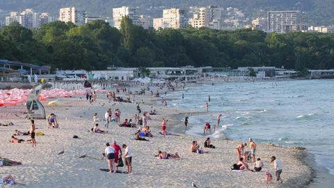 Crowded urban beach with people sunbathing and swimming Stock Footage 339048084
