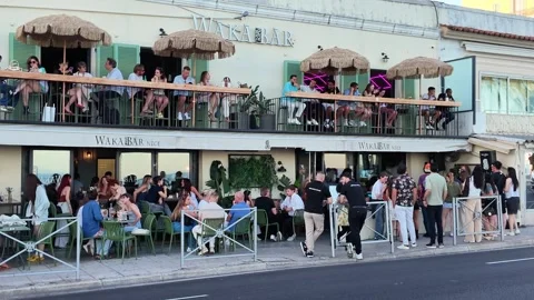 Crowded Waka Bar facade in Nice with people relaxing at sunset Stock Footage 336922844