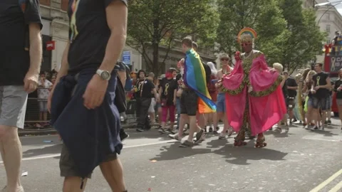 CROWDS AND DRAG QUEEN ROLLERSKATING THROUGH LONDON GAY PRIDE PARADE Stock Footage 130744679