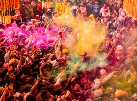 Crowds can be seen below duirng Holi Festival in India, throwing powdered pai Stock Photos