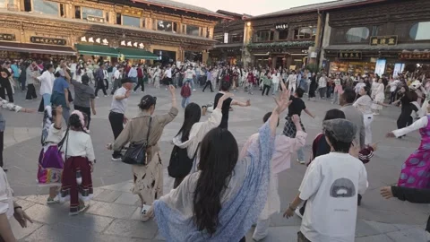 Crowds dancing Tibetan circle dance on Shangri-La square, Yunnan Province, China Stock Footage 336006308