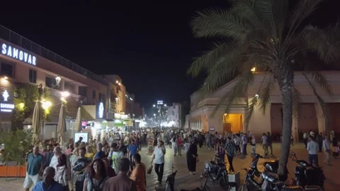 Crowds explore Marrakech's Jemaa el-Fnaa market square in a lively night scene Stock Footage 336756822